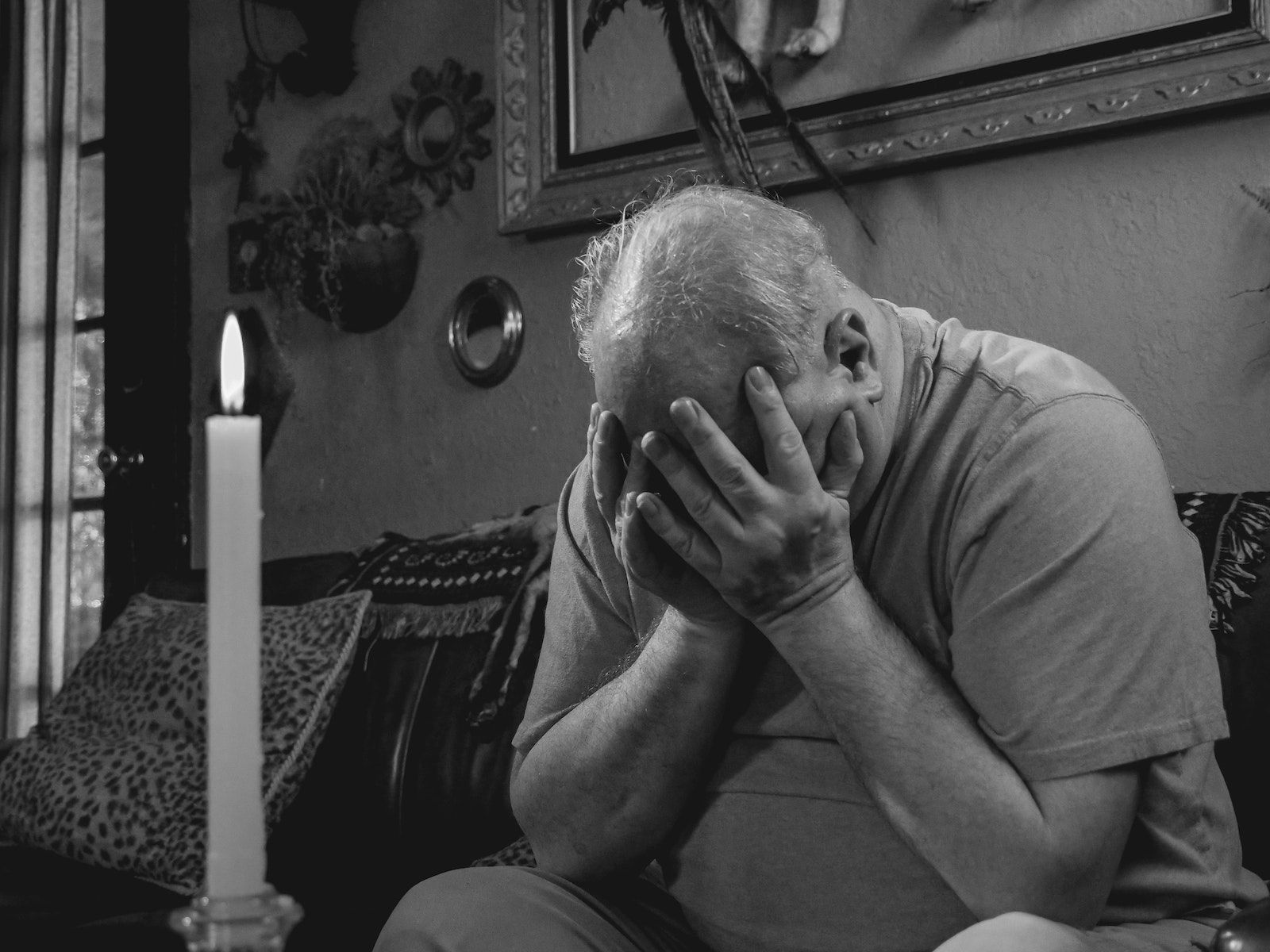 Grayscale Photo of Man Covering His Face with Hands