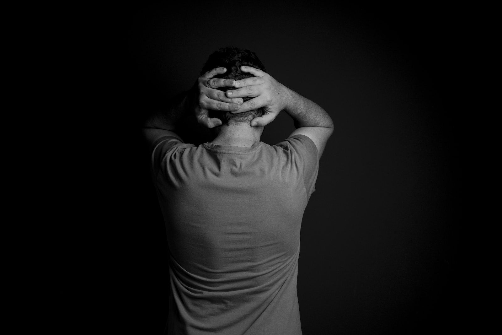 Man Touching Back of the Head with Hands